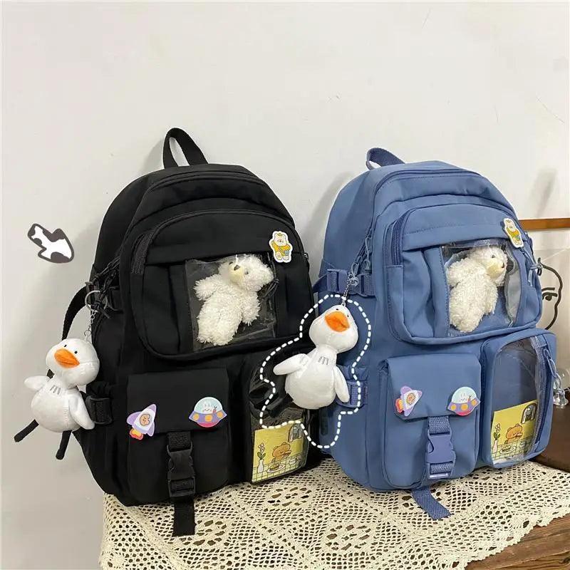 Black and blue nylon backpacks with plush bear in front clear pocket and charm accessories