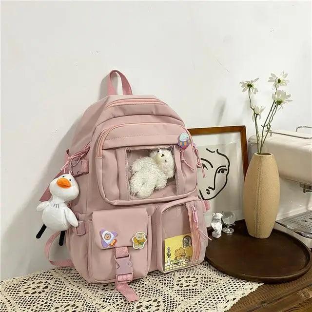 Pink nylon mini backpack with front organizer pocket, cartoon patches, plush bear and duck charm