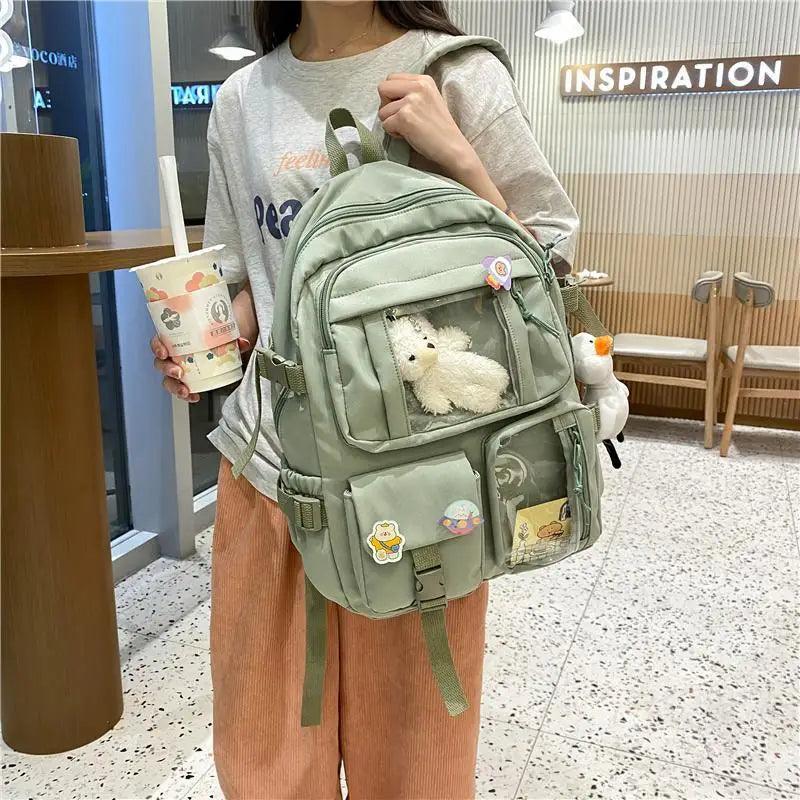 Light green nylon backpack with front zipper pocket and attached plush animal keychain