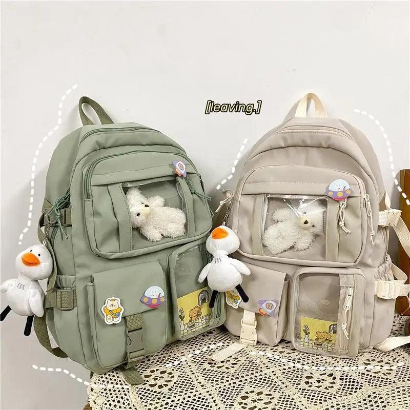 Pair of backpacks: mint green and beige with plush toys and front accessory charms