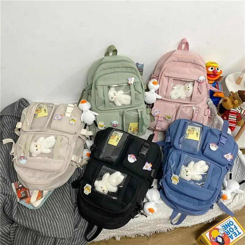 Multi-color set of backpacks: mint, pink, beige, black, and blue with plush charms