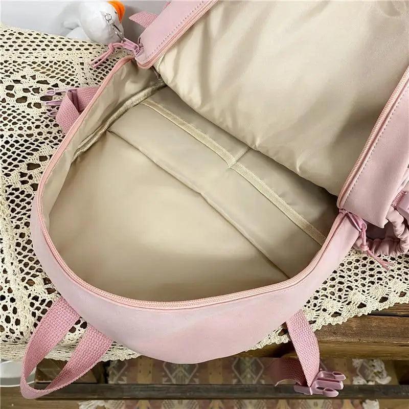 Pink nylon backpack open with large inner compartment and zippered side pocket