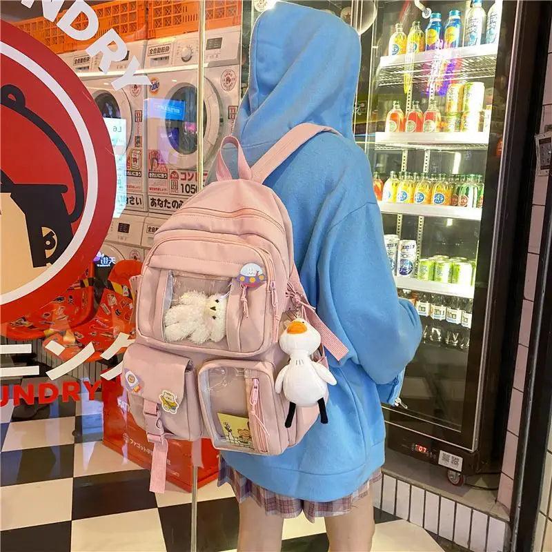 Pink nylon mini backpack with front pockets, cartoon patches, plush bear and keychain