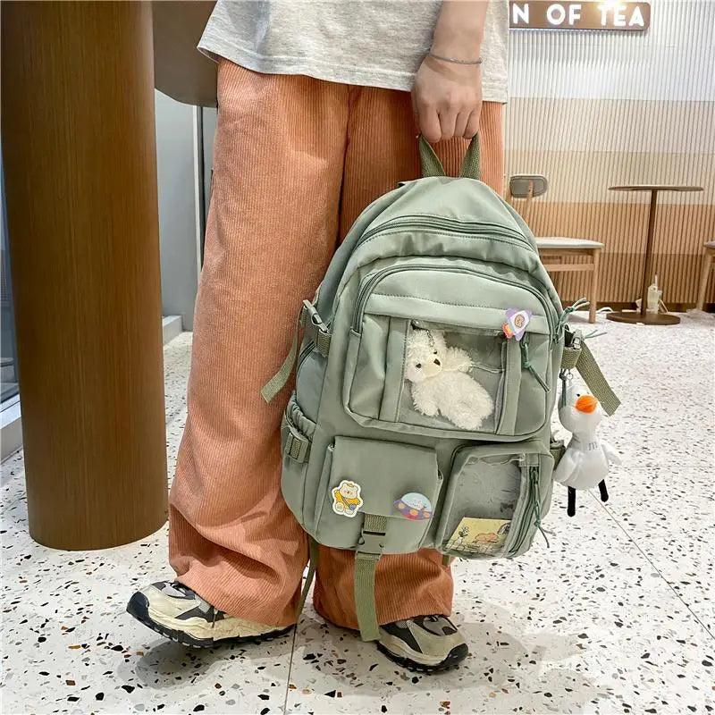 Olive green nylon backpack with front pockets and plush animal inside