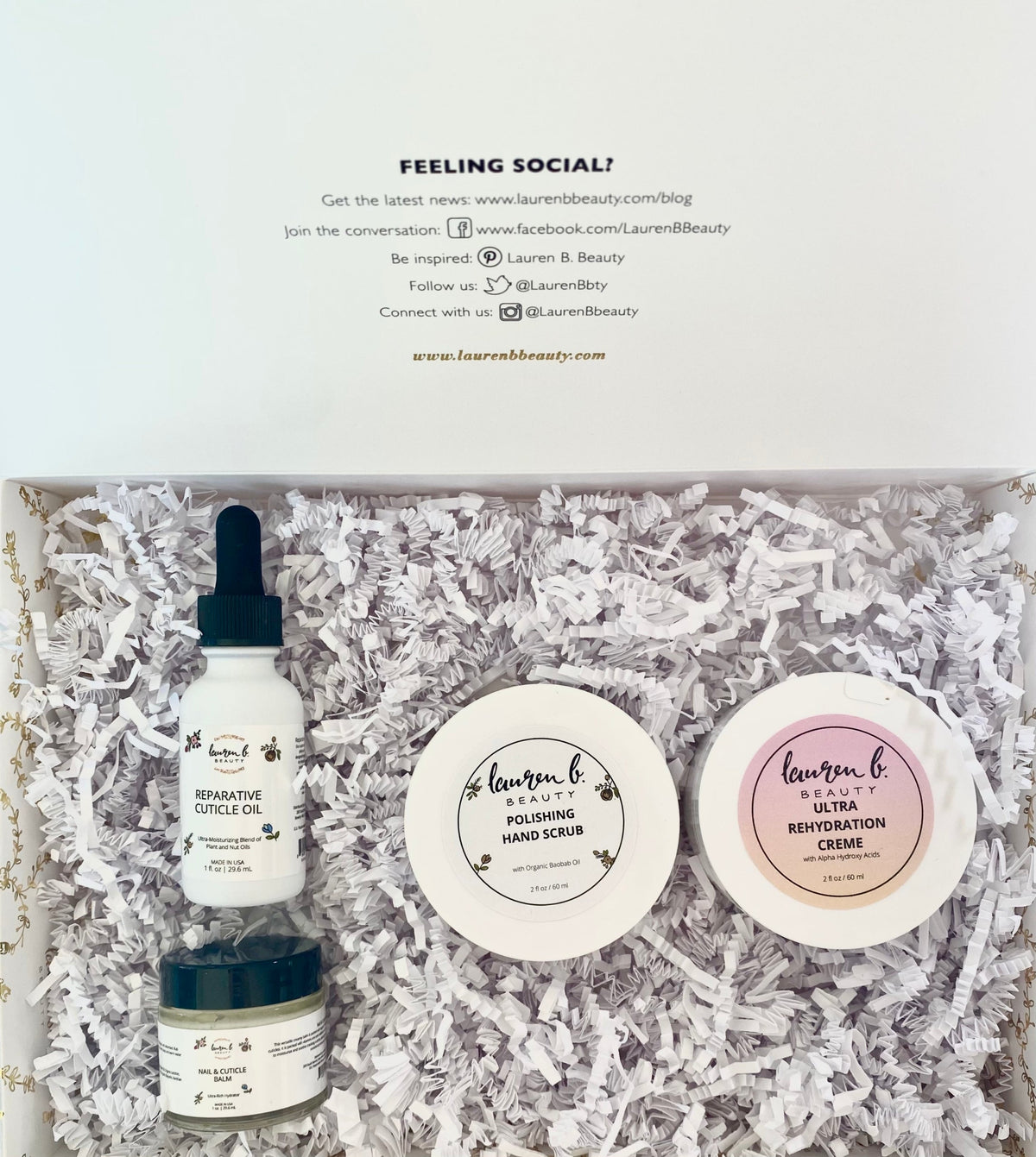 Open hand care gift collection box with skincare products and shredded filler