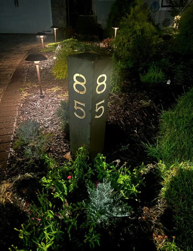 Solar address pillar light with lit numbers 8, 5 and 5 on a tall steel post