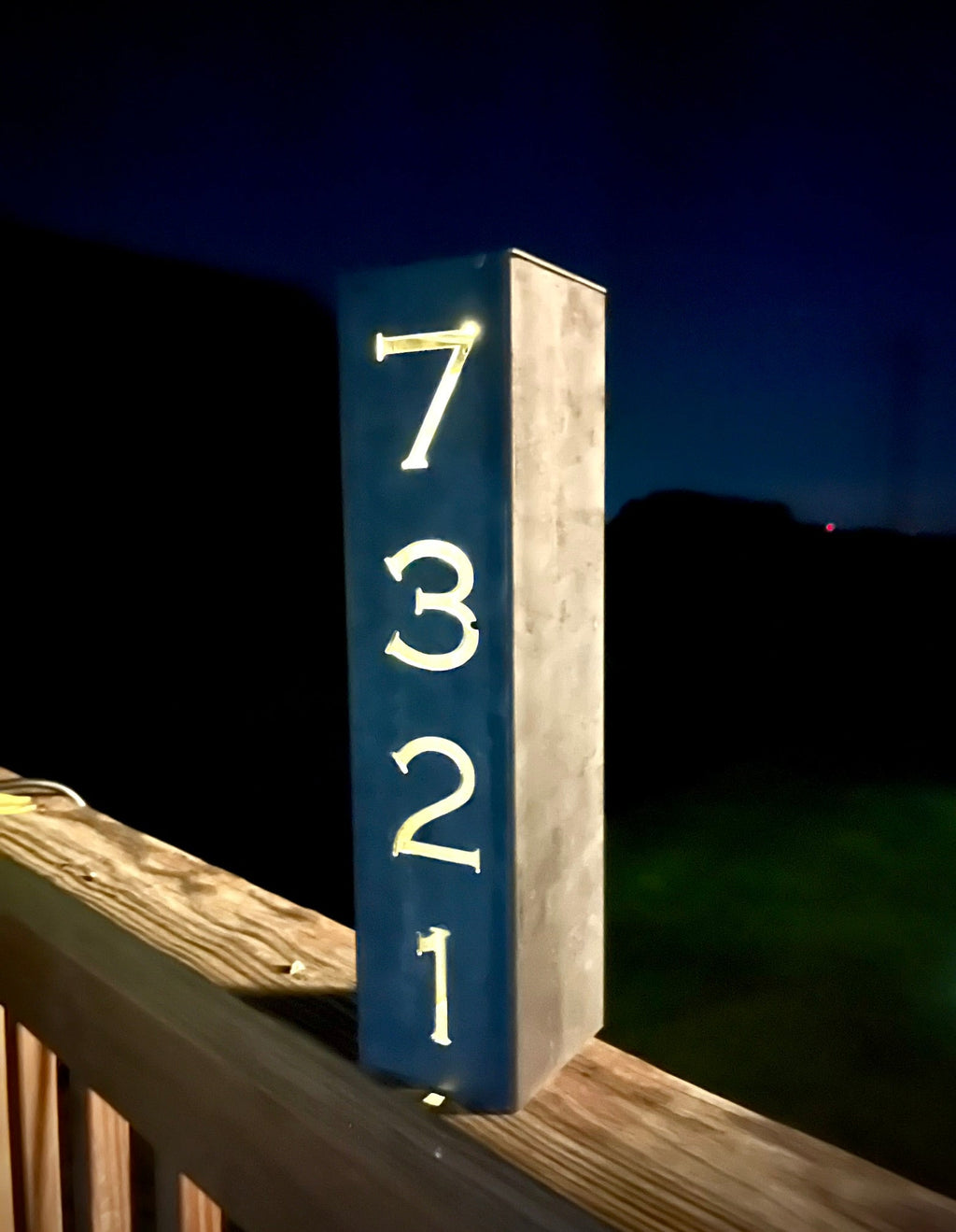 Steel solar address pillar light with glowing numbers 7, 3, 2, and 1 on the post