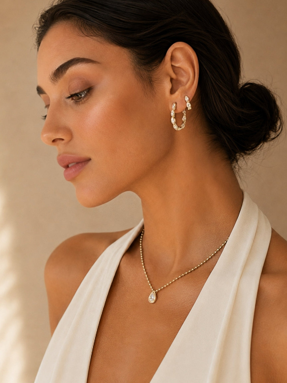 Gold marquise hoop earrings with oval crystal drops on side profile