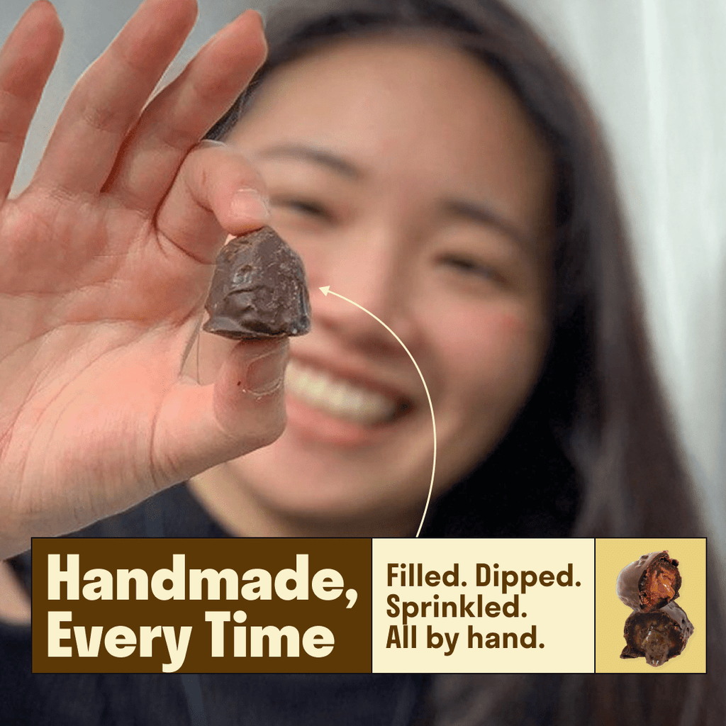 Chocolate stuffed date held in hand, bite mark and filling visible
