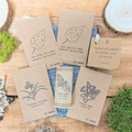 Houseplant seed collection with five labeled seed packets on kraft paper