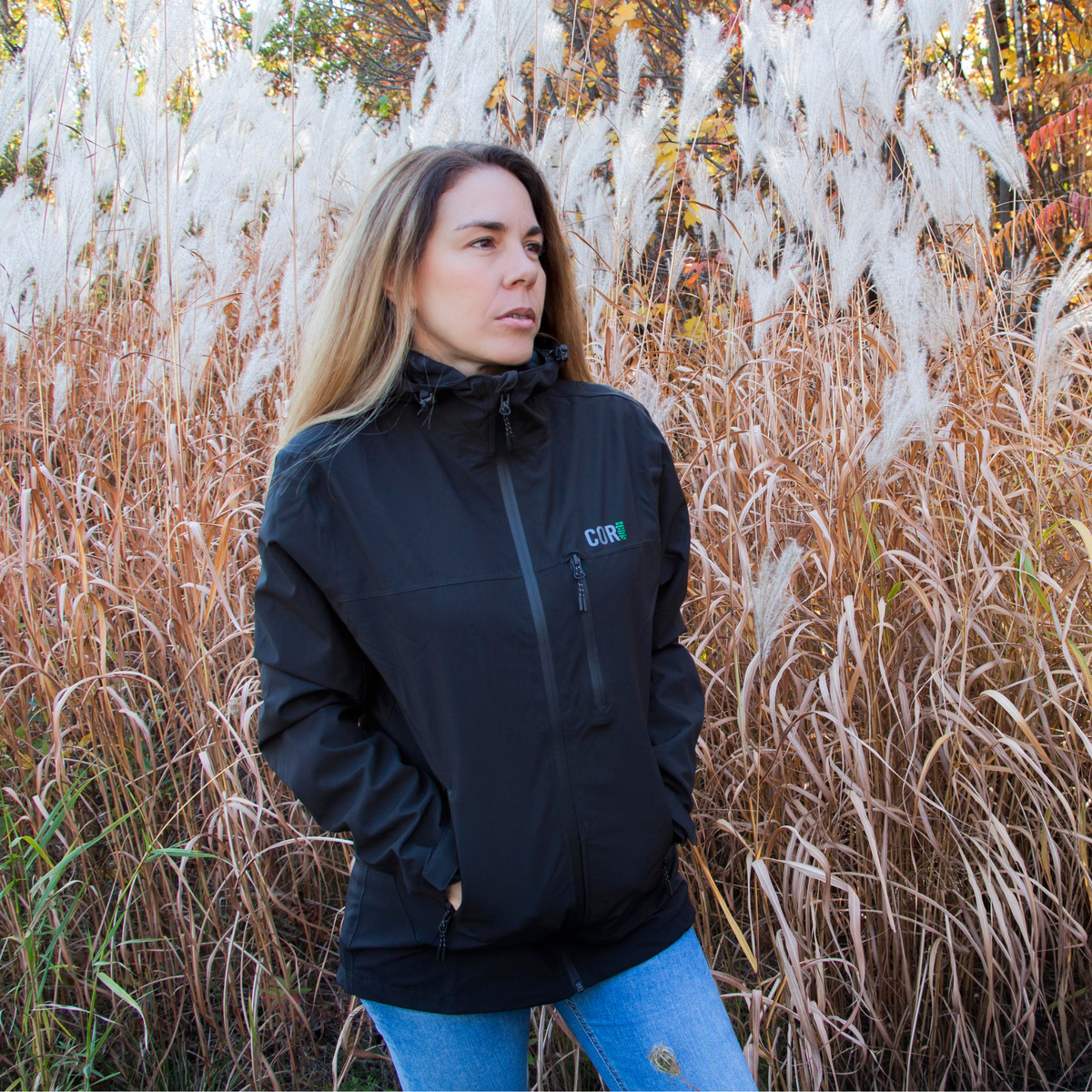 Black travel rain jacket with hood, front zipper, and drawcord hem