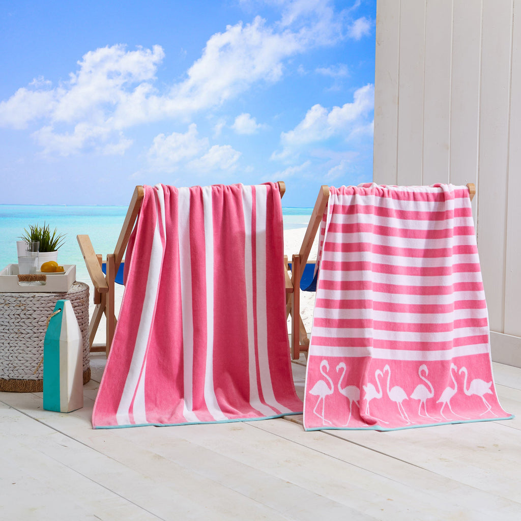Pink cotton velour beach towels on wooden chairs, including striped and flamingo-style prints
