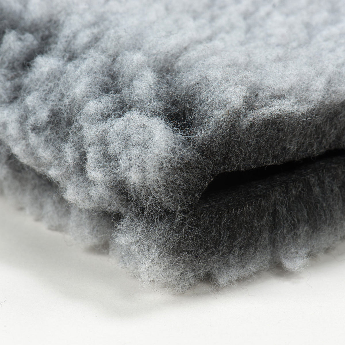 Close-up of gray fleece mat bed with fluffy, textured surface