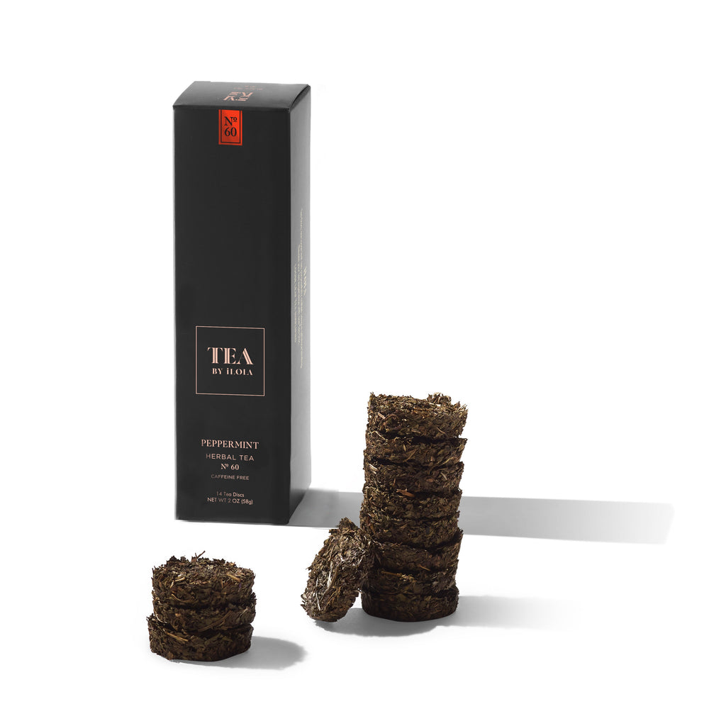 Peppermint loose-leaf herbal tea discs beside a black Tea by Hojo box