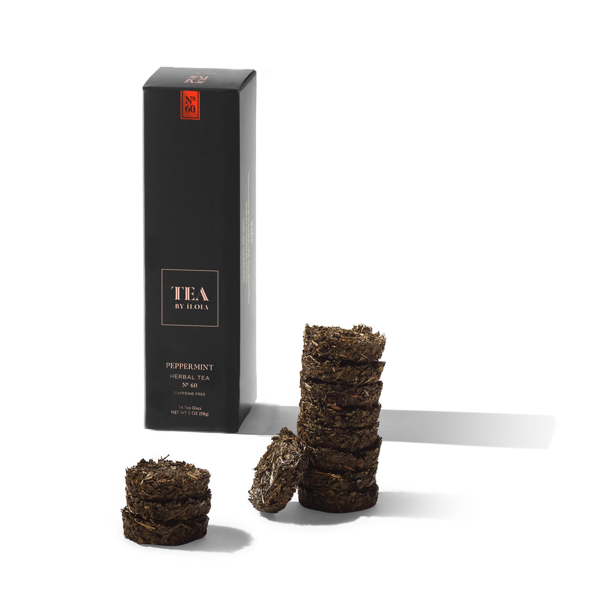 Peppermint loose-leaf herbal tea discs beside a black Tea by Hojo box