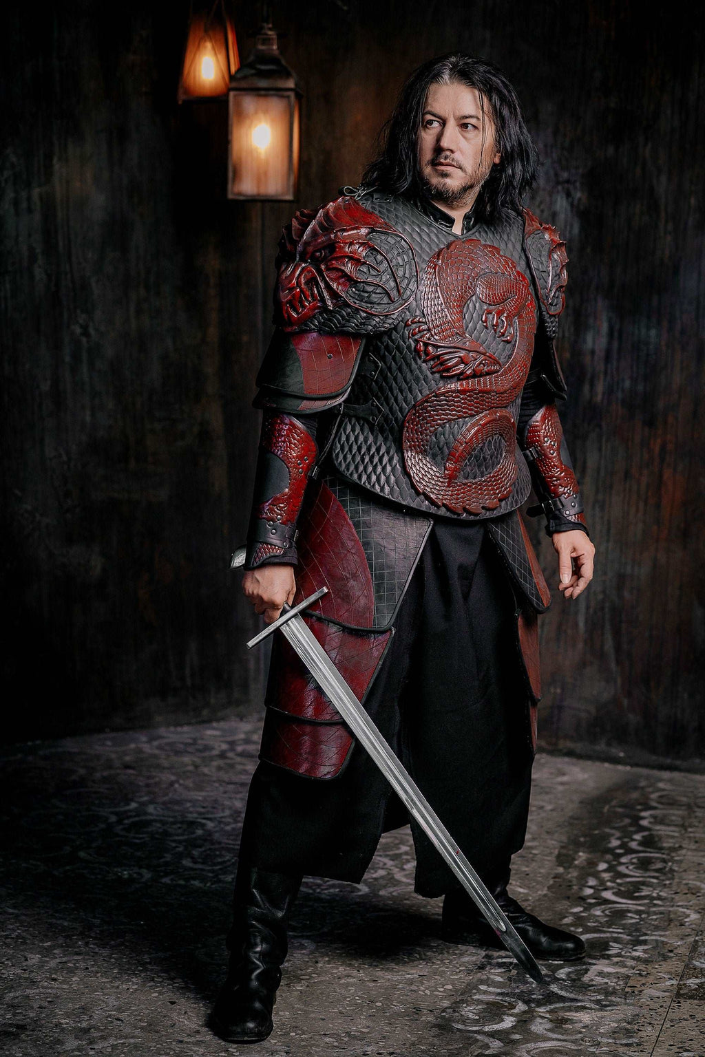 Vampire knight armor costume standing with sword, red-and-gray scale chest armor