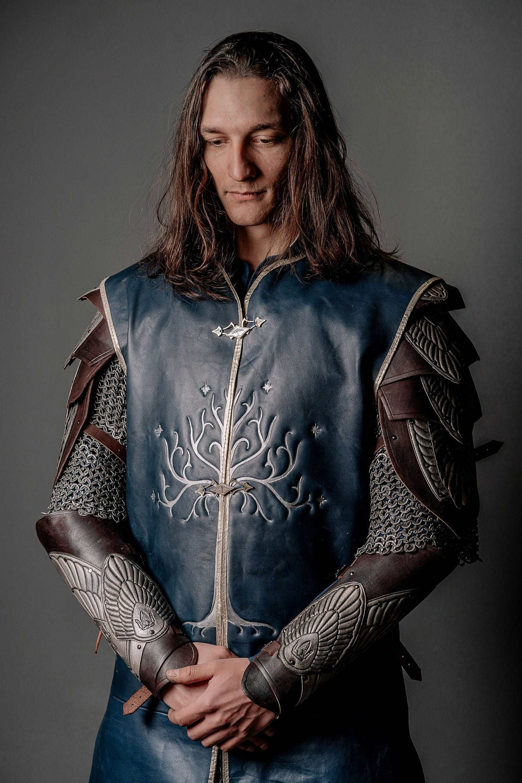 Blue tunic with silver tree-and-cross embroidery and plated arm bracers