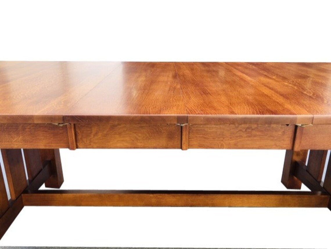 Dining table leg detail with solid wood apron and underframe crossbar.
