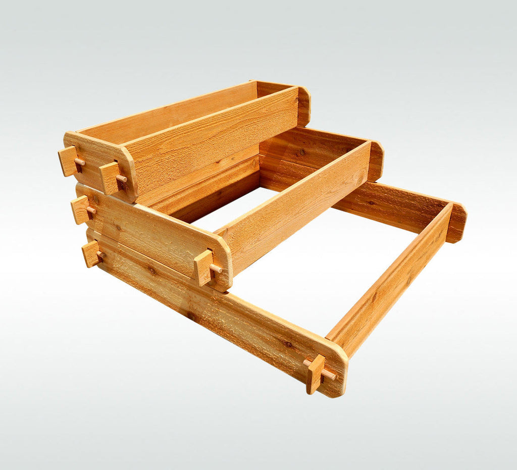 Light cedar three-tier raised planter kit with interlocking corner brackets, studio view