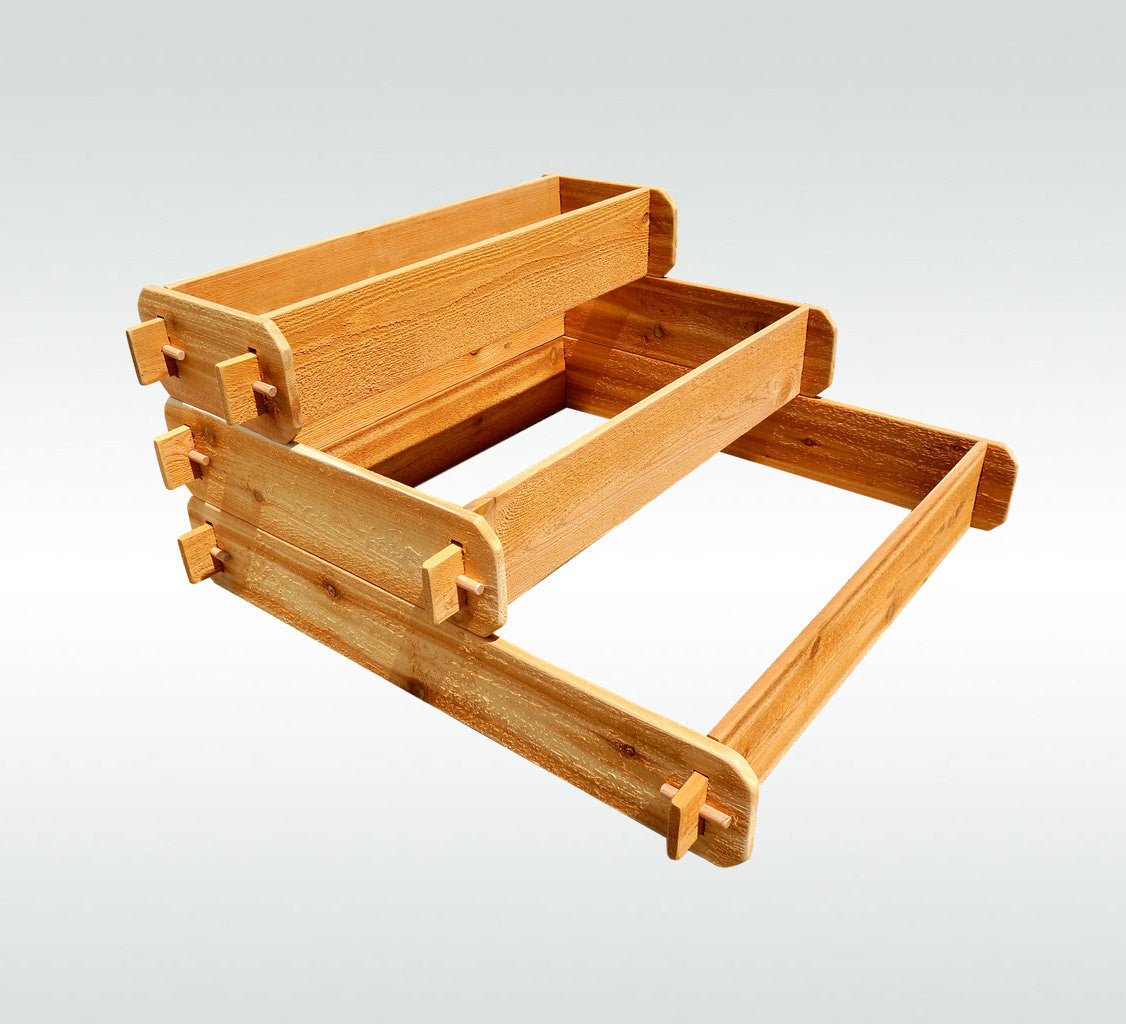 Light cedar three-tier raised planter kit with interlocking corner brackets, studio view