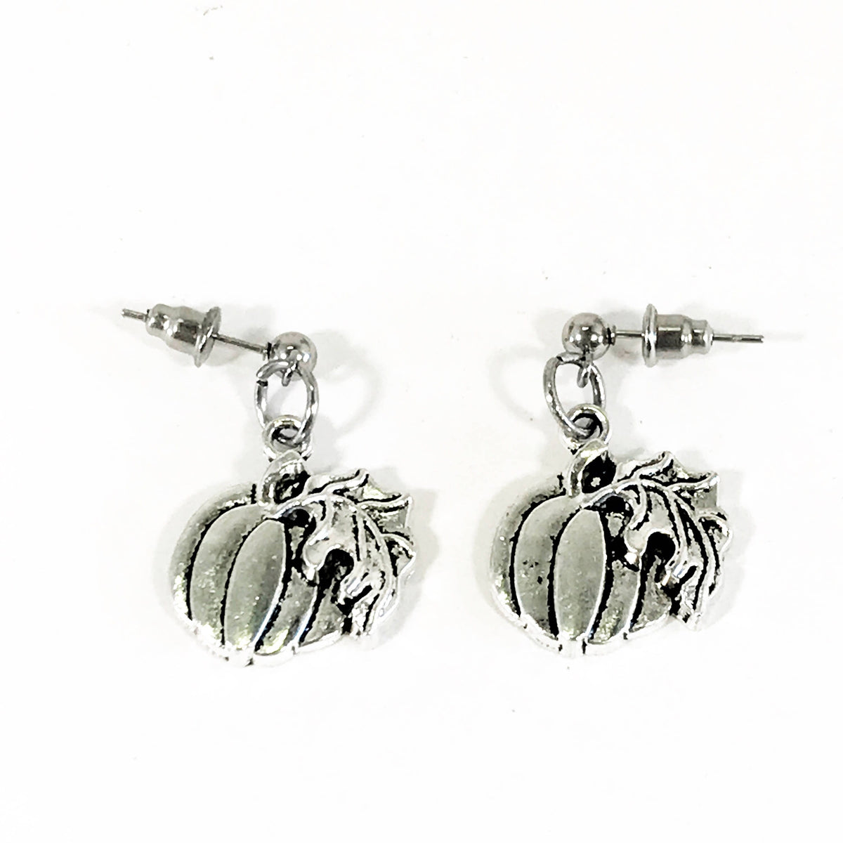 Silver-tone pumpkin dangle earrings with leaf stem and circular stud posts.