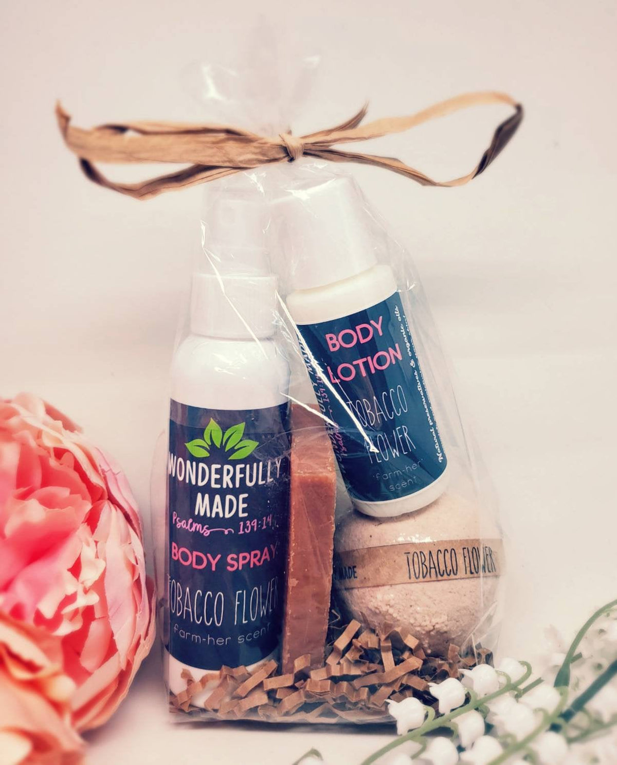 Wrapped bath and body gift bundle with dark blue labels, tied with ribbon