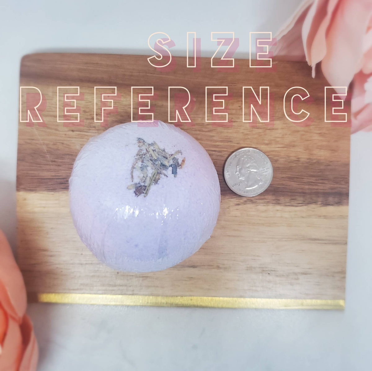 Lavender round bath bomb with dried herb pieces, shown next to a coin
