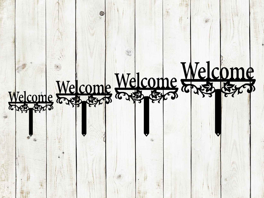 Multiple black "Welcome" yard stake signs with ornate scroll cutout and pointed bottoms
