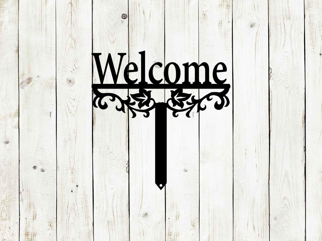 Black "Welcome" yard stake sign on white wooden background with ornate scroll design