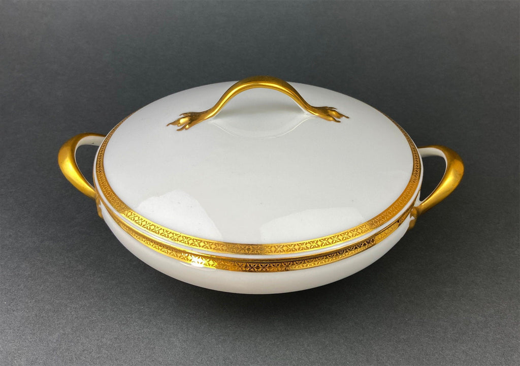 White porcelain covered serving dish with gold lion finial and gold trim border
