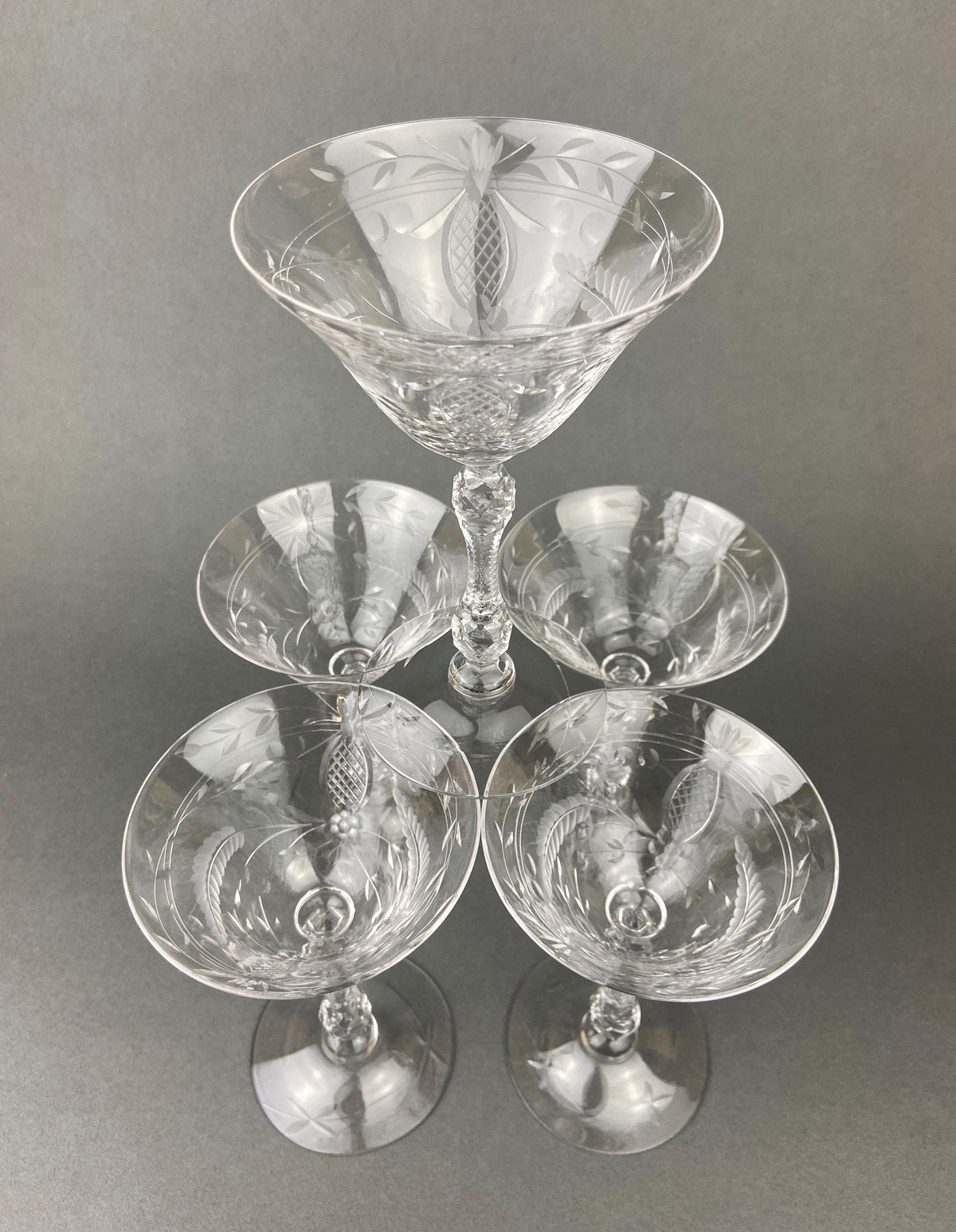 Cut crystal champagne glasses arranged together, faceted stems and decorative bowls