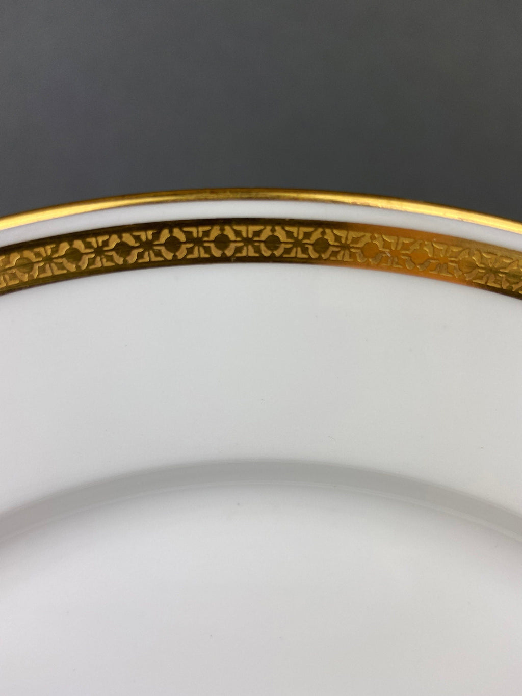 Porcelain rim close-up with gold border and decorative patterned gold band