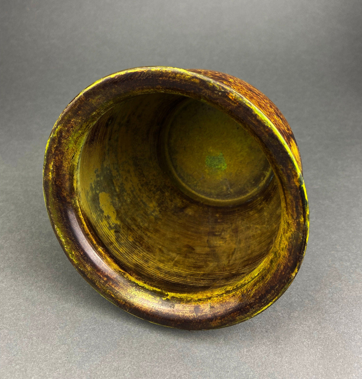 Hammered brass vase interior with circular base, open top view