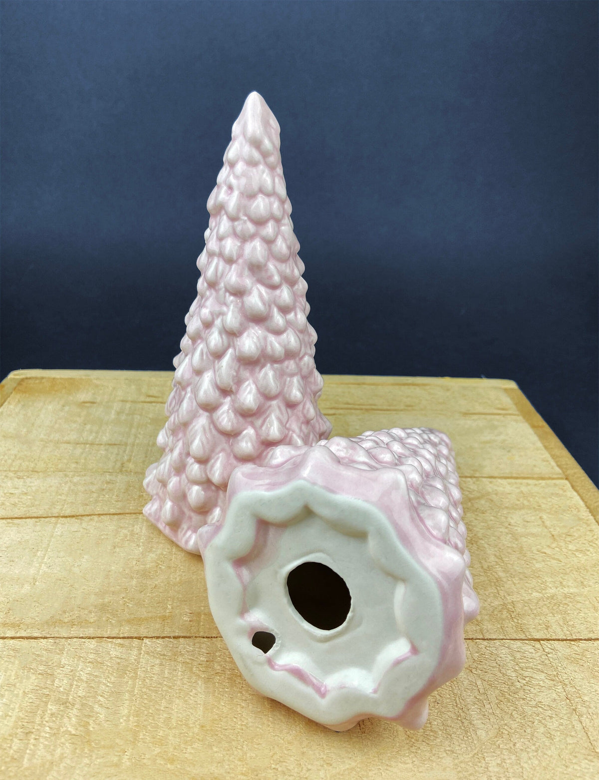 Pink ceramic Christmas tree figurine with circular scalloped base and cutout