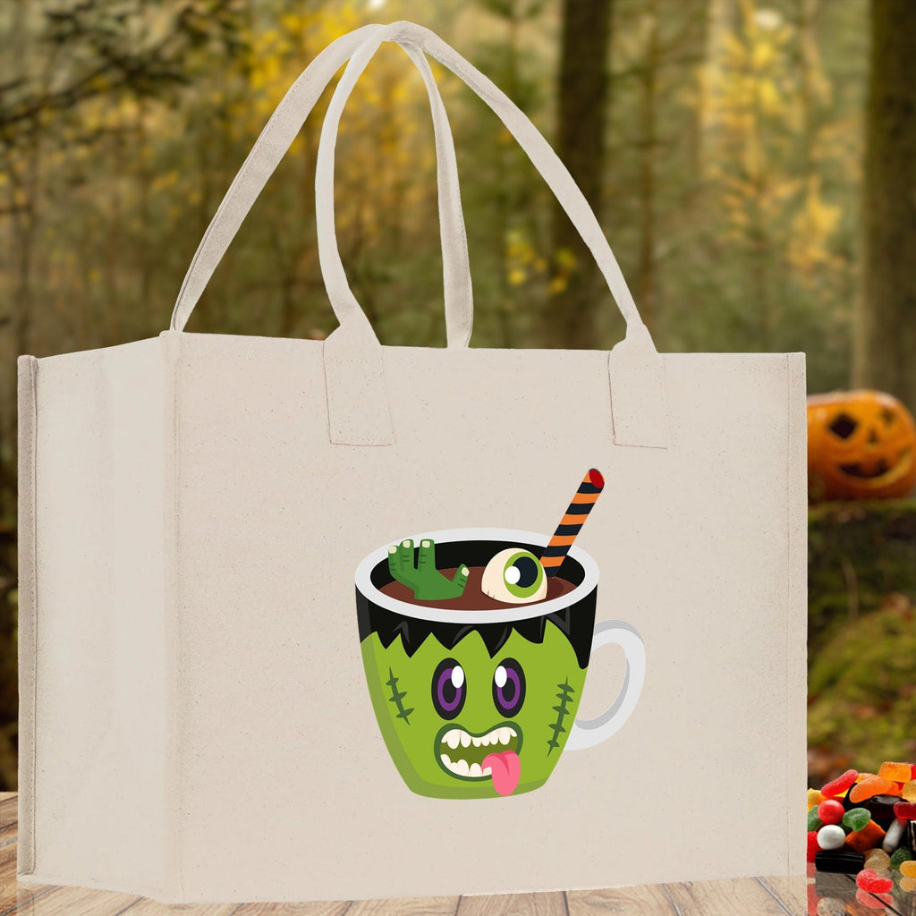 Natural canvas tote bag with green monster potion cup Halloween graphic and white handles