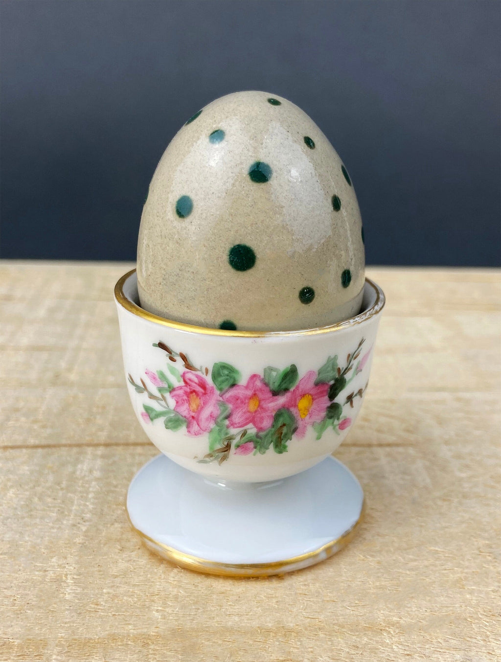 Porcelain egg cup with pink floral trim and gold base stand
