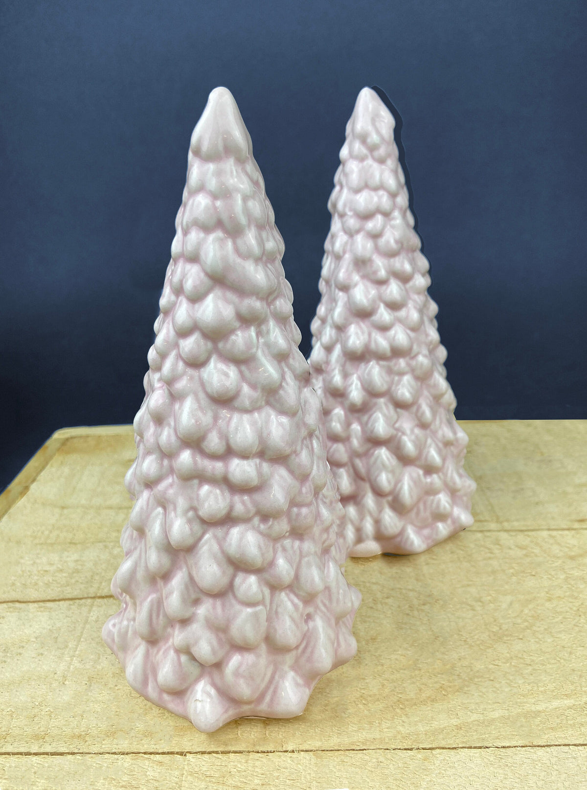 Pair of pink ceramic Christmas tree figurines with textured stacked bulb details