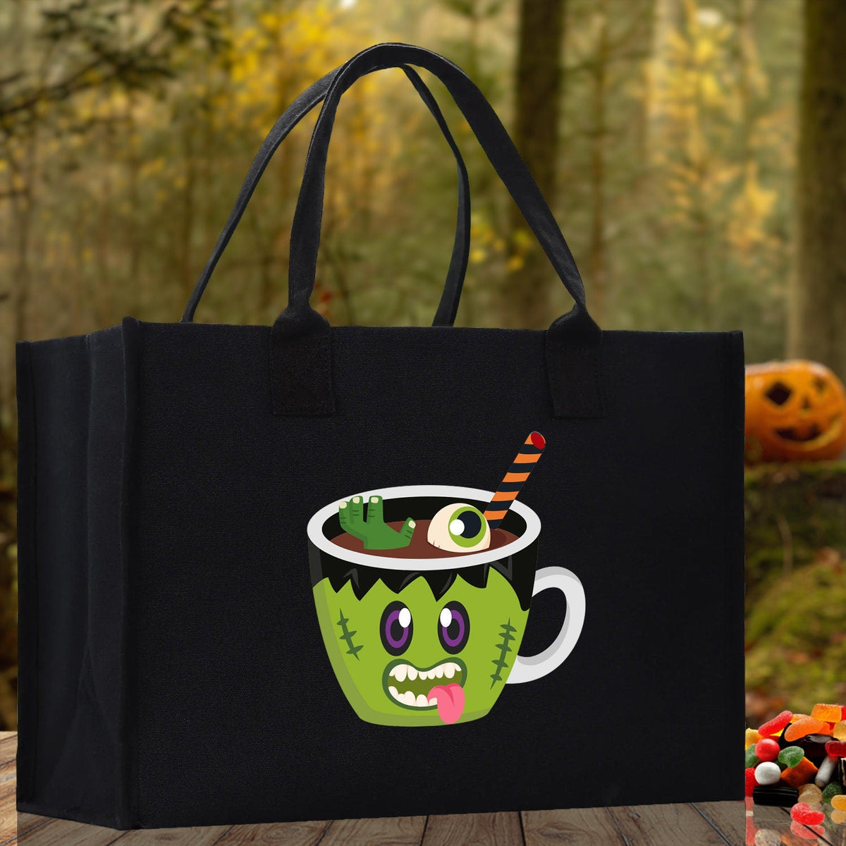 Black canvas tote bag with green monster potion cup Halloween graphic and black handles