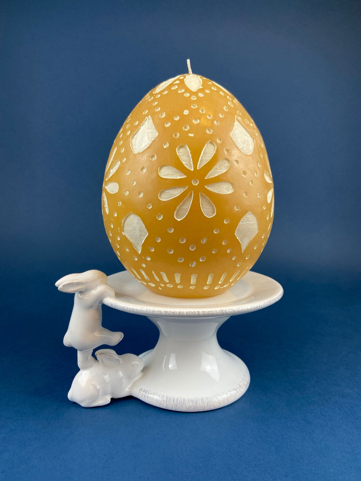 White ceramic bunny cupcake stand holding a golden speckled egg topper