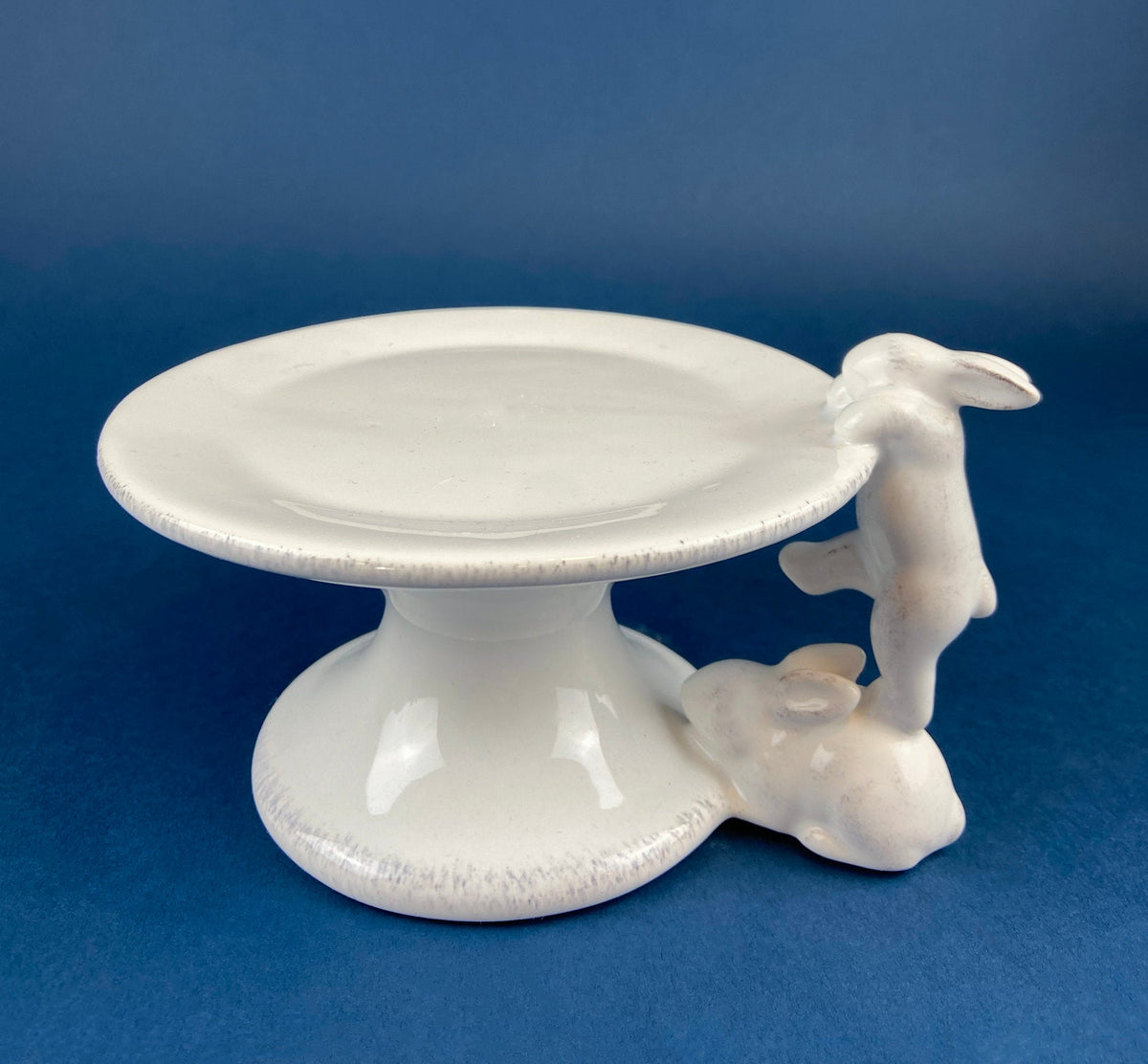 White ceramic bunny cupcake stand with round plate top and climbing rabbit figurine