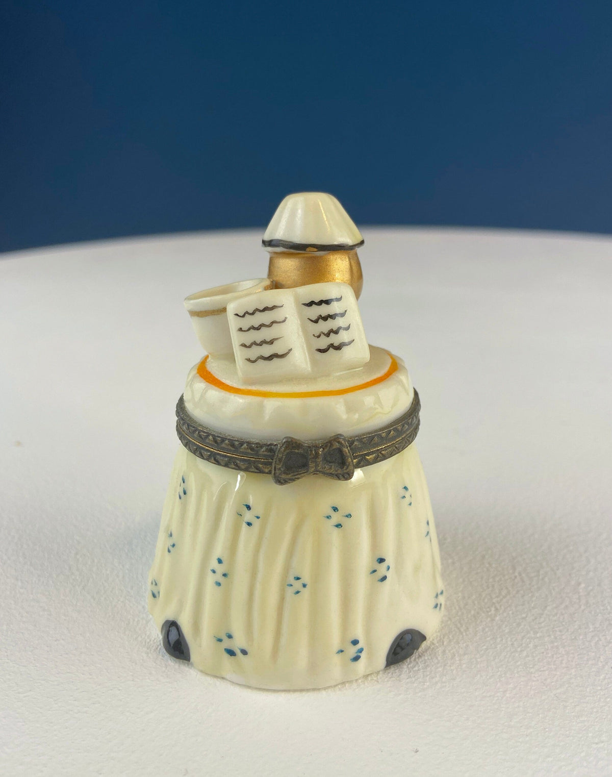 Miniature porcelain pill box with cream fabric pattern and gold tipped lid