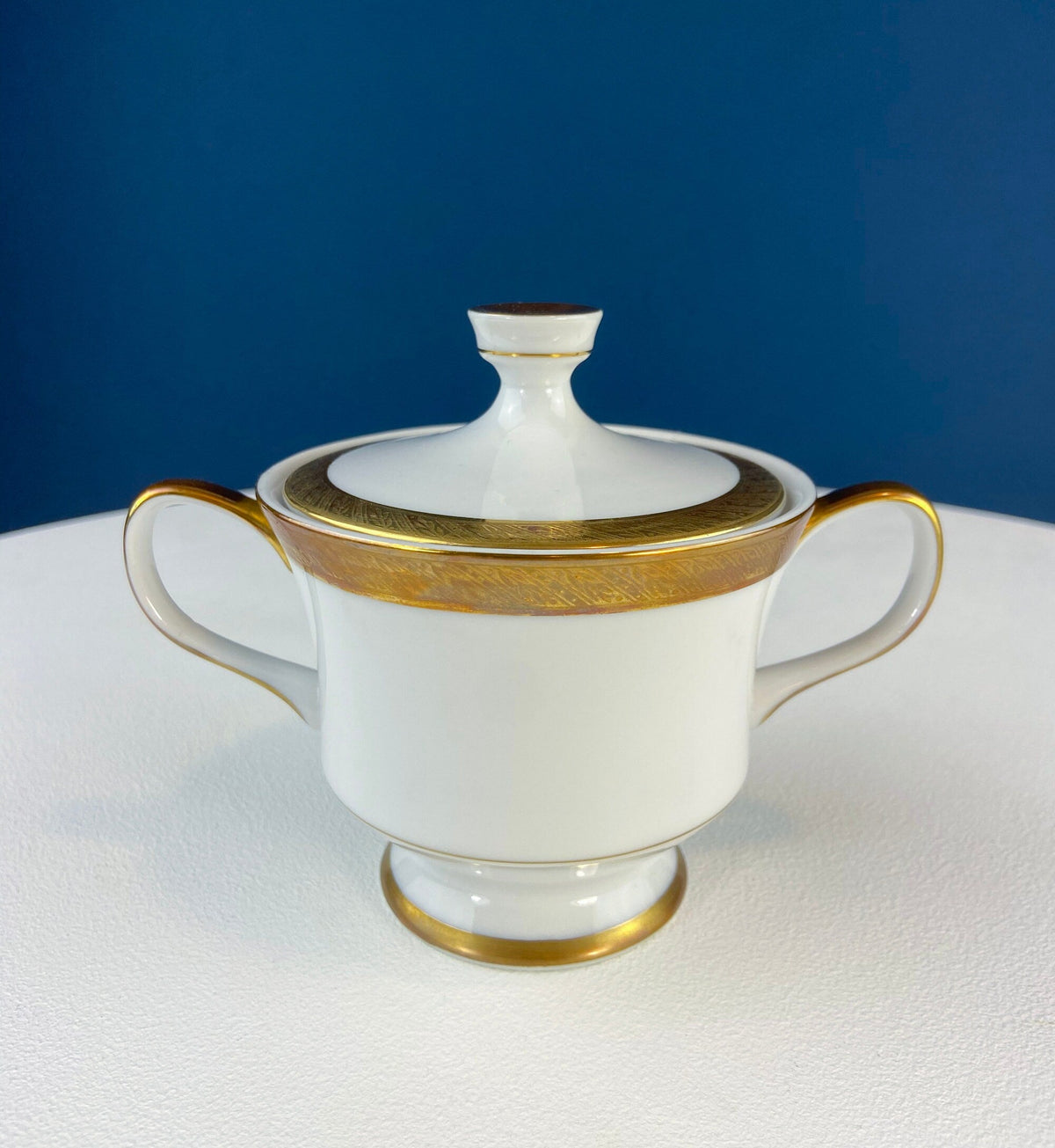White porcelain covered sugar bowl with gold band and side handles
