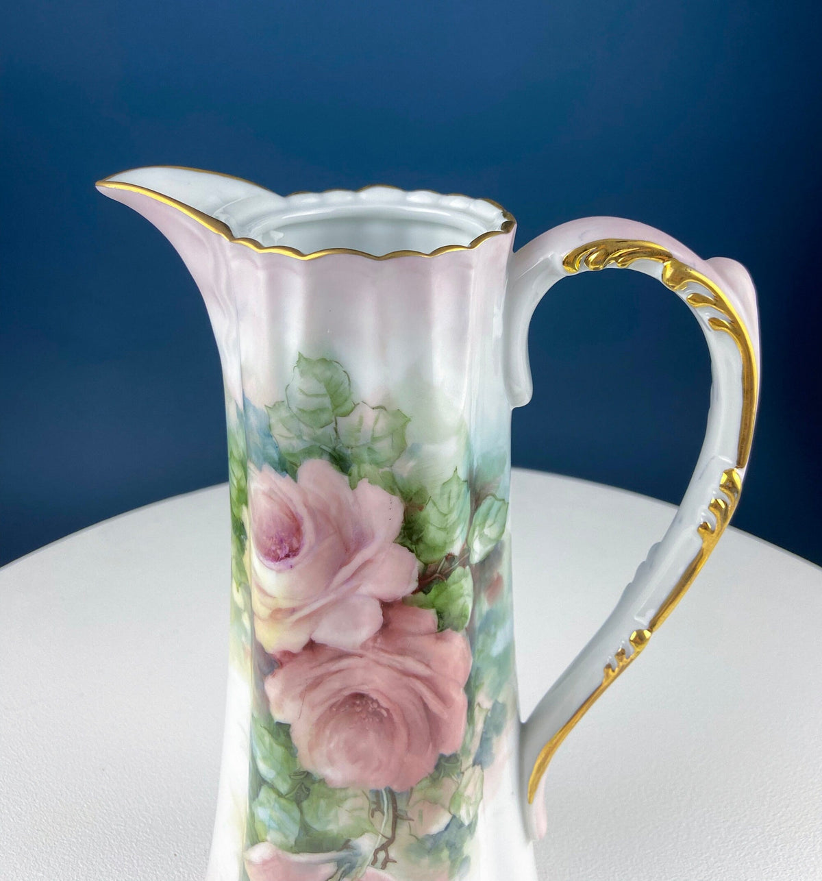 Porcelain hot chocolate pot close view of painted pink roses and green leaves