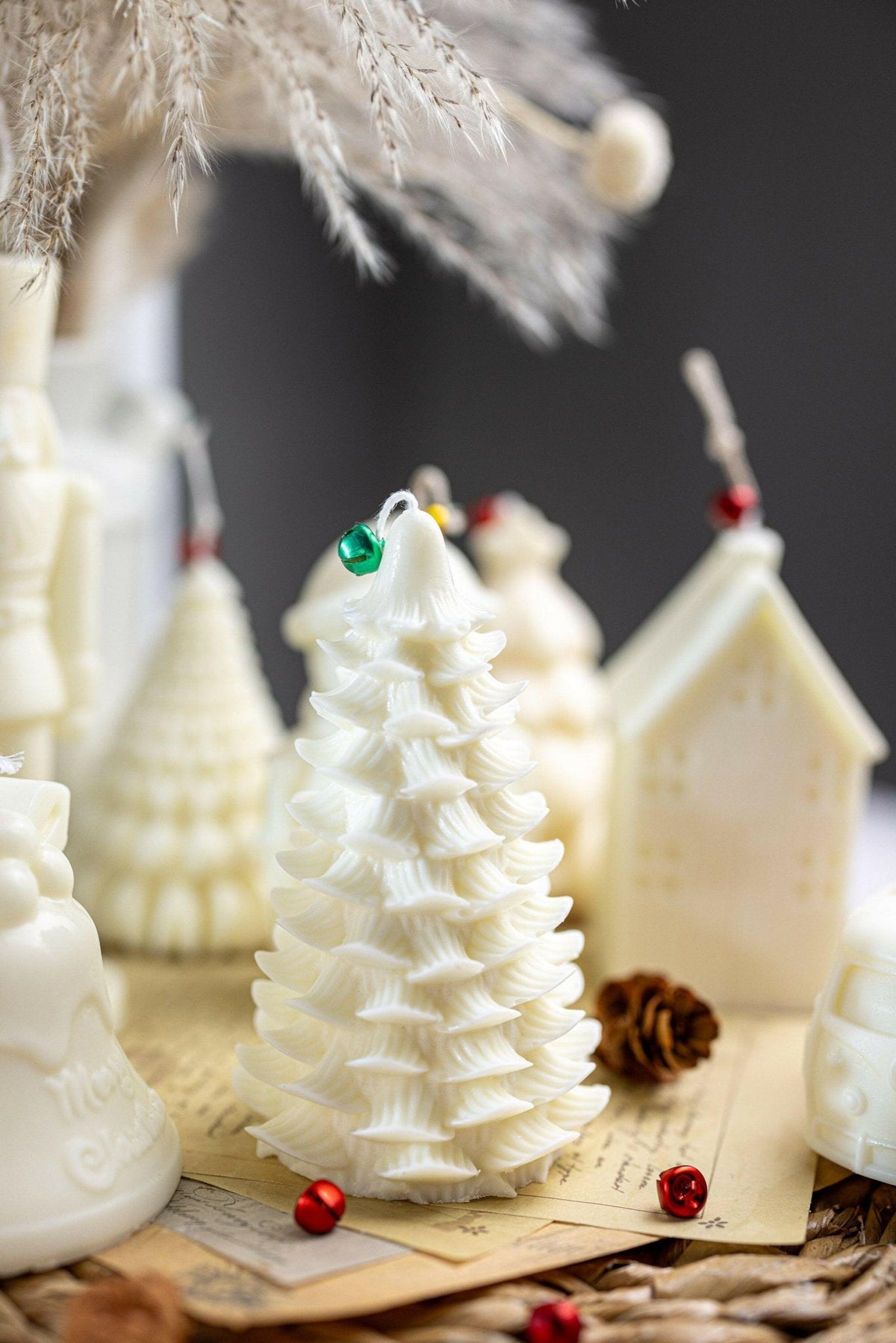 White Christmas tree soy candle with snowflake-like ridges on wooden base with ornaments