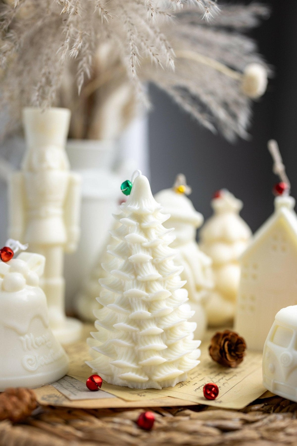 White Christmas tree shaped soy candle on wooden base with red and green ornament pieces