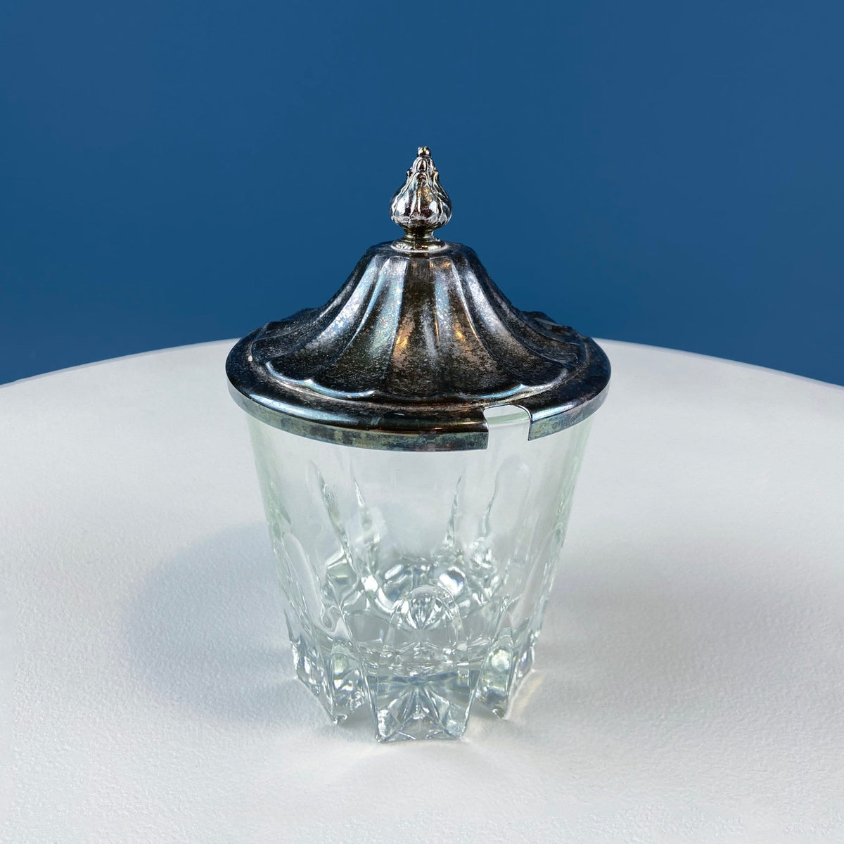 Clear glass serving jar with ornate silver plated lid and decorative finial