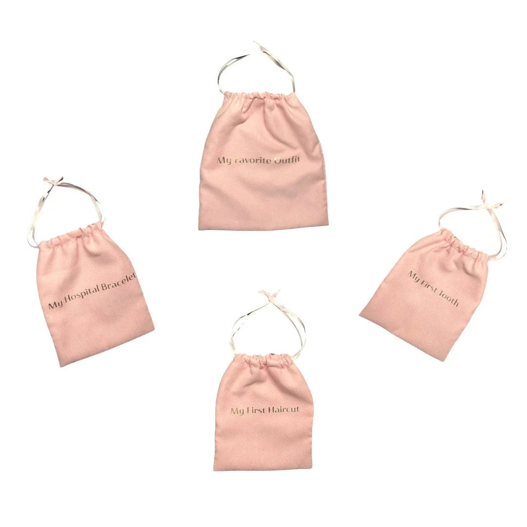Set of pink fabric keepsake bags with drawstring and embroidered milestone text