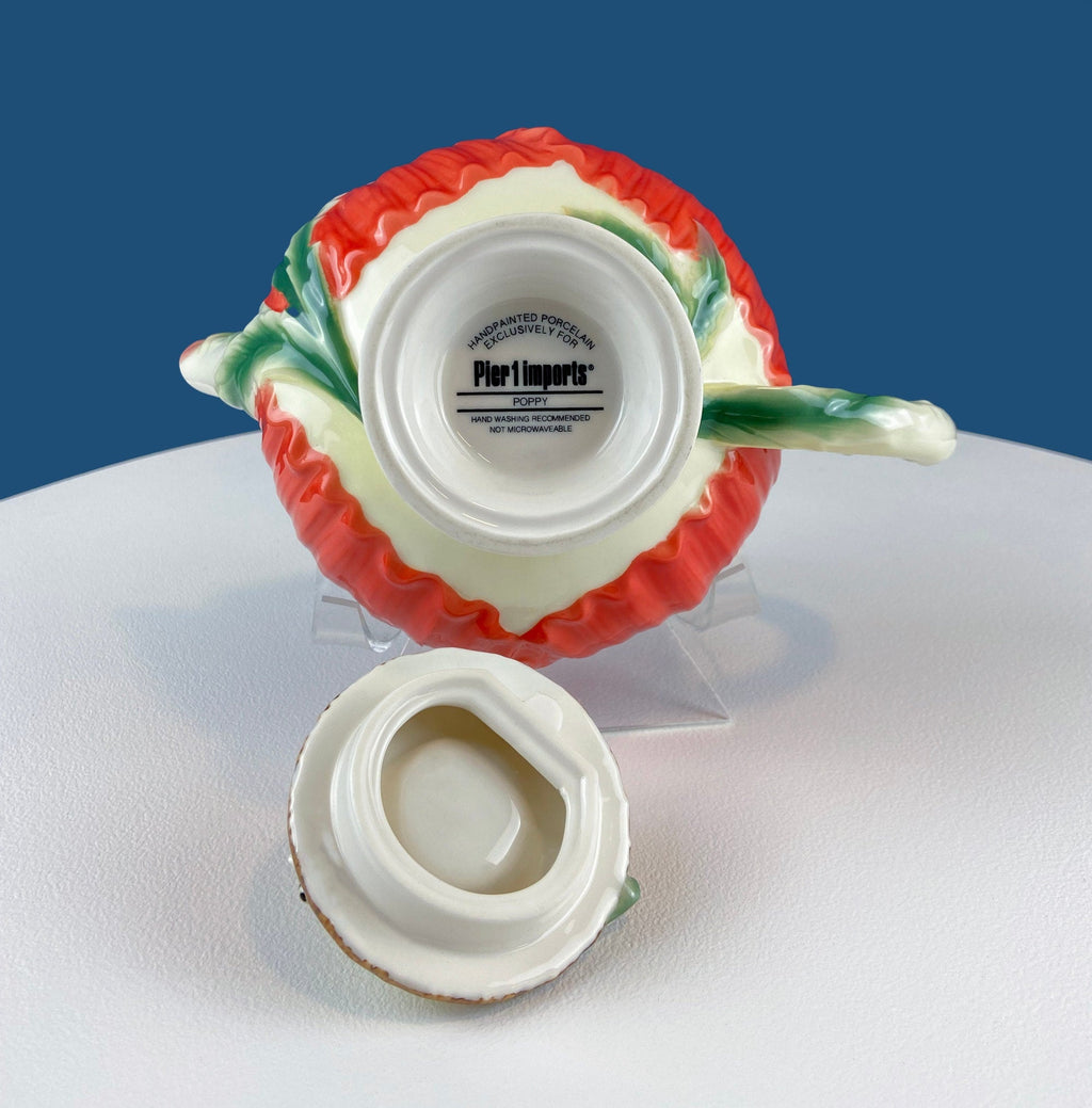 Red poppy teapot underside with white base and printed brand label