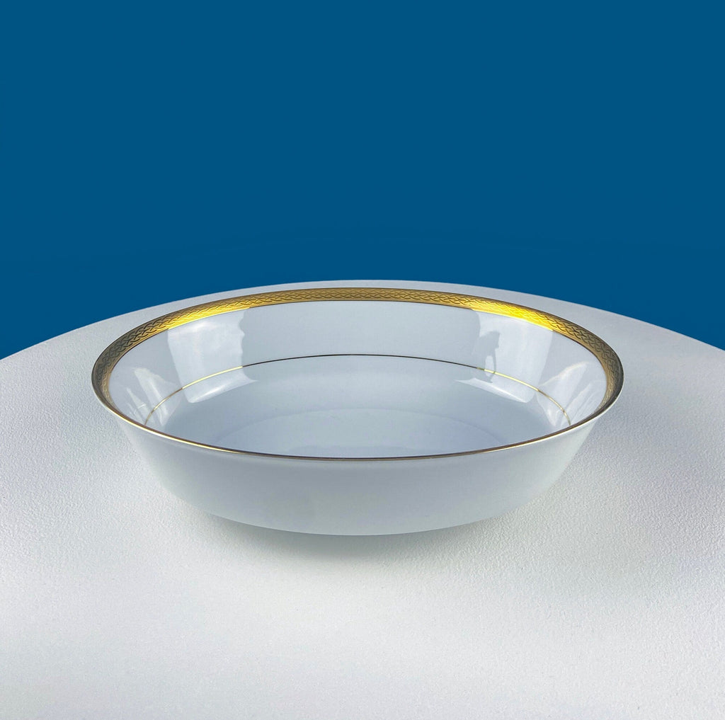 White porcelain oval serving bowl with gold embossed rim and thin gold band