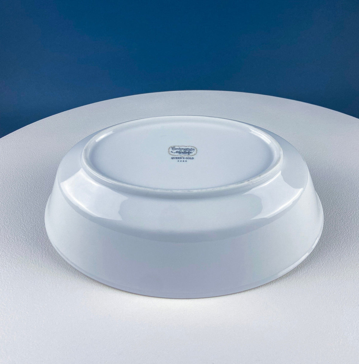 White porcelain oval bowl underside with maker mark and glossy finish